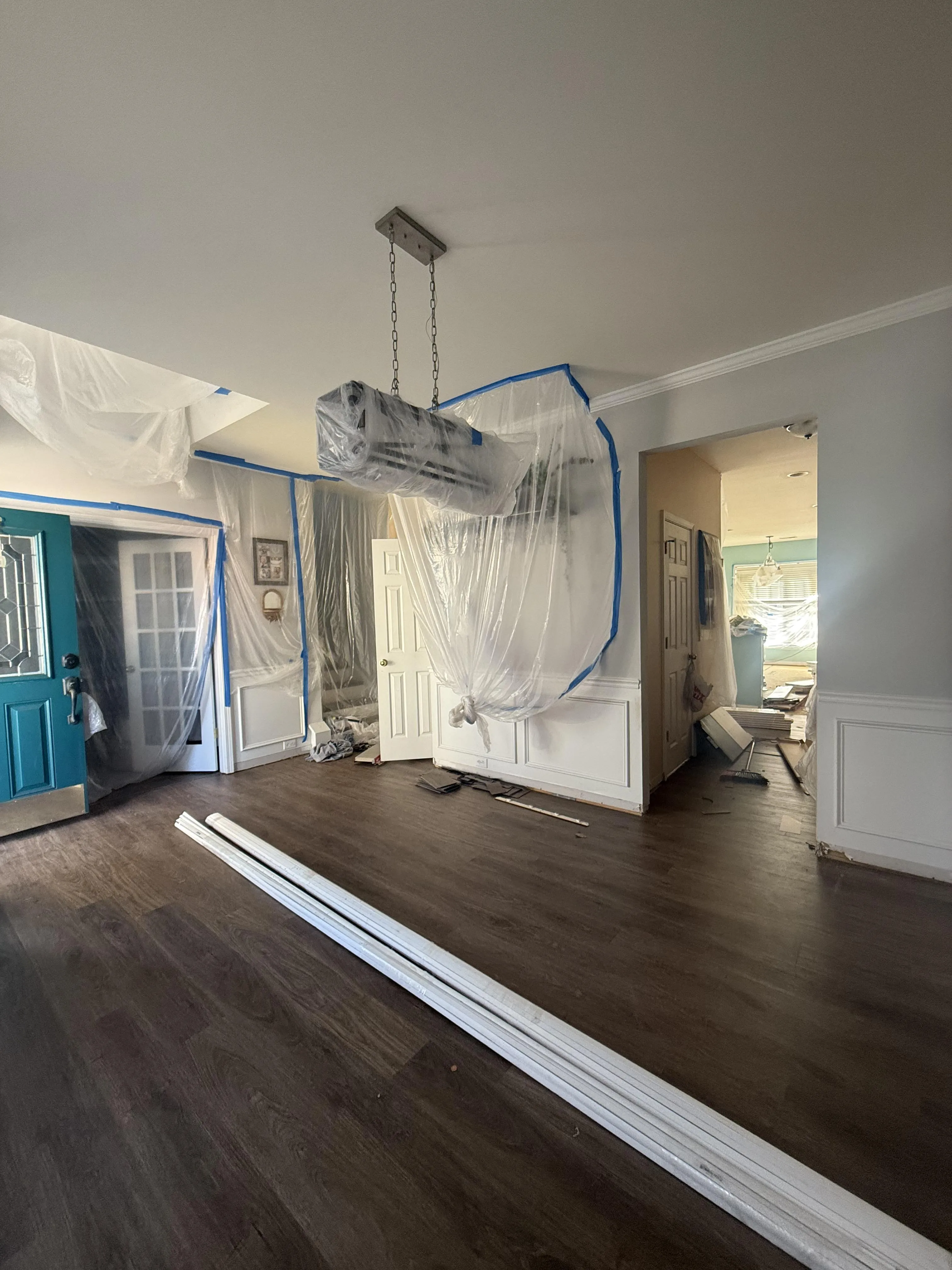 New baseboard and trim staged for installation over new flooring on a Carolina Pro Restoration rebuild