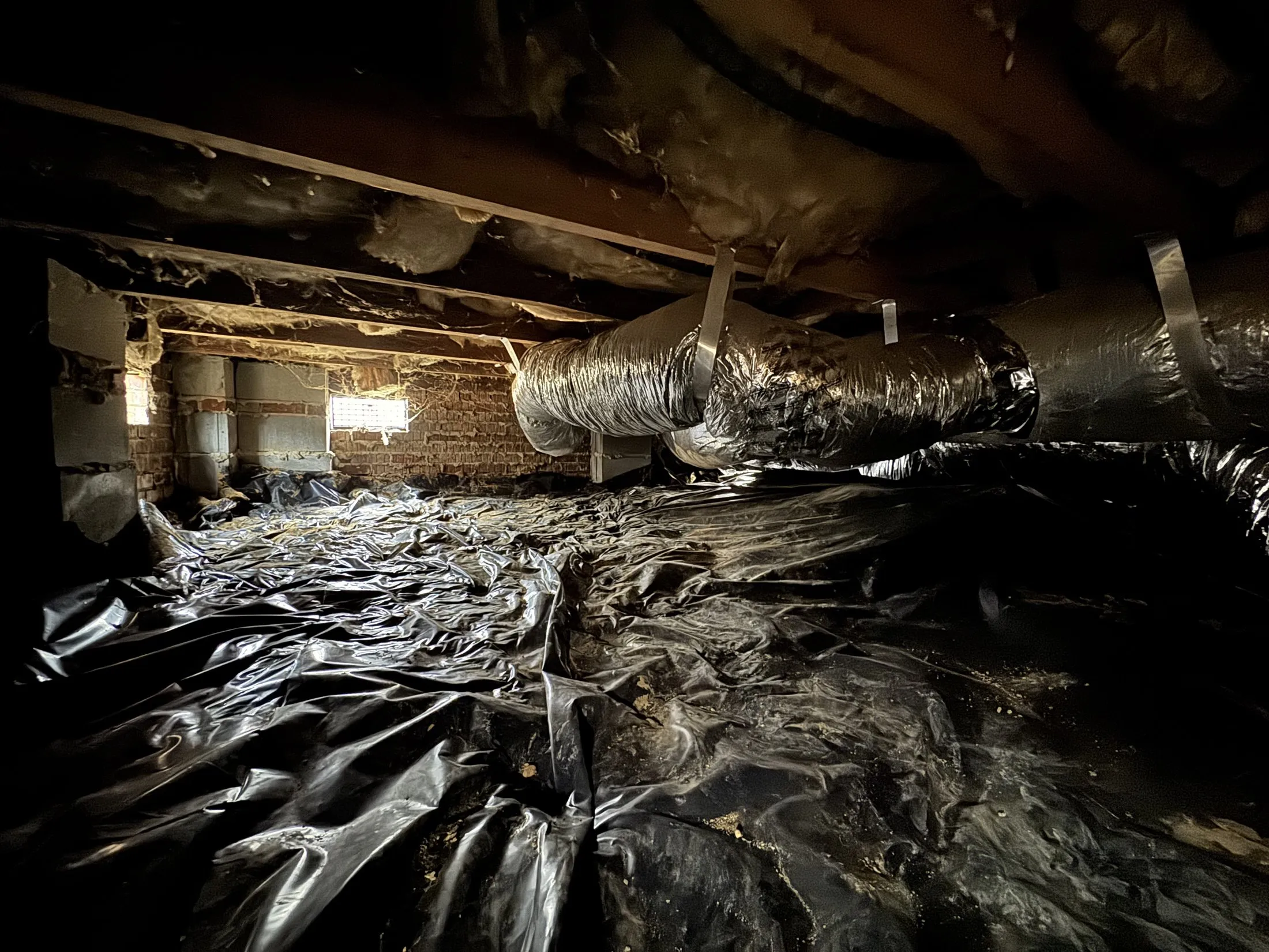 A sealed crawl space with a heavy black vapor barrier under a Lake Wylie area home